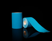 Load image into Gallery viewer, Ocean Blue™ 10 and 5cm Hestaband™ Cotton kinesiology tape shown in hand to demonstrate tape width, texture, and material quality.